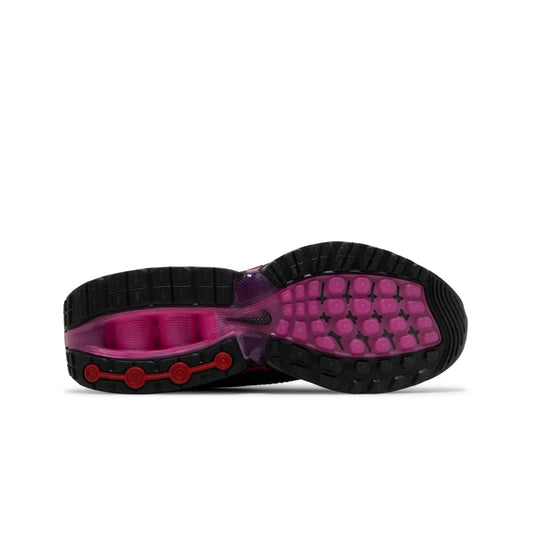 Close-up of a shoe sole with black, pink, and red design on a white background