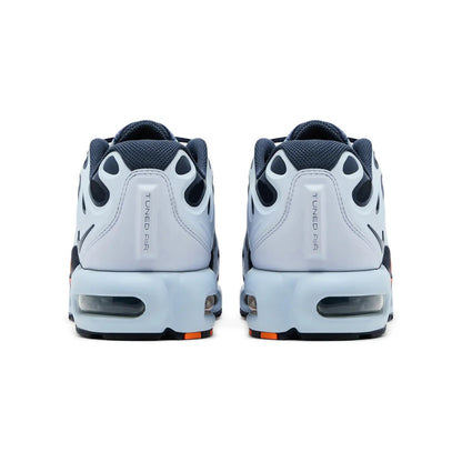 Pair of white sneakers with black and orange accents on a white background