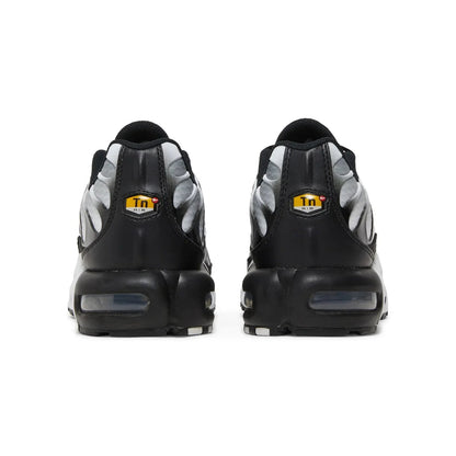 Black and gray sneakers with a yellow logo on a white background