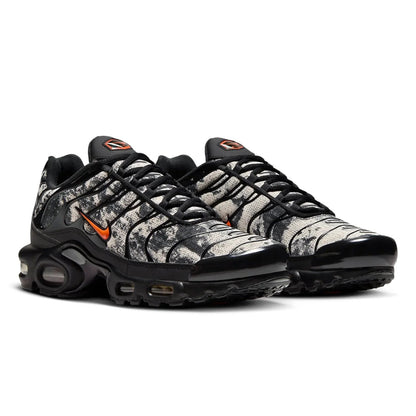 Black and gray sneaker with orange accents on a white background