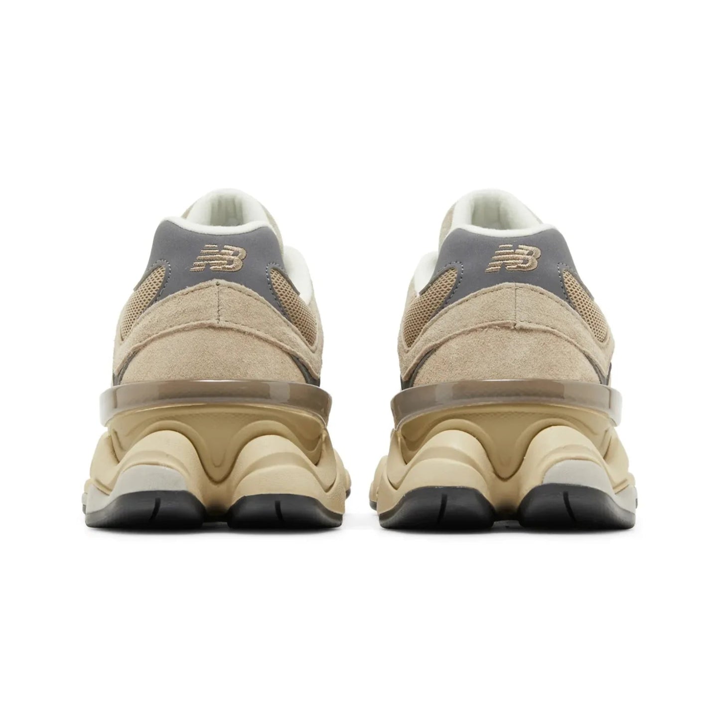 Pair of beige sneakers with black soles on a white background