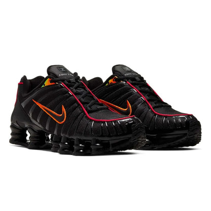 Black athletic shoes with orange accents on a white background