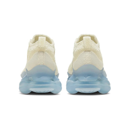 Pair of cream-colored sneakers with blue sole on a white background