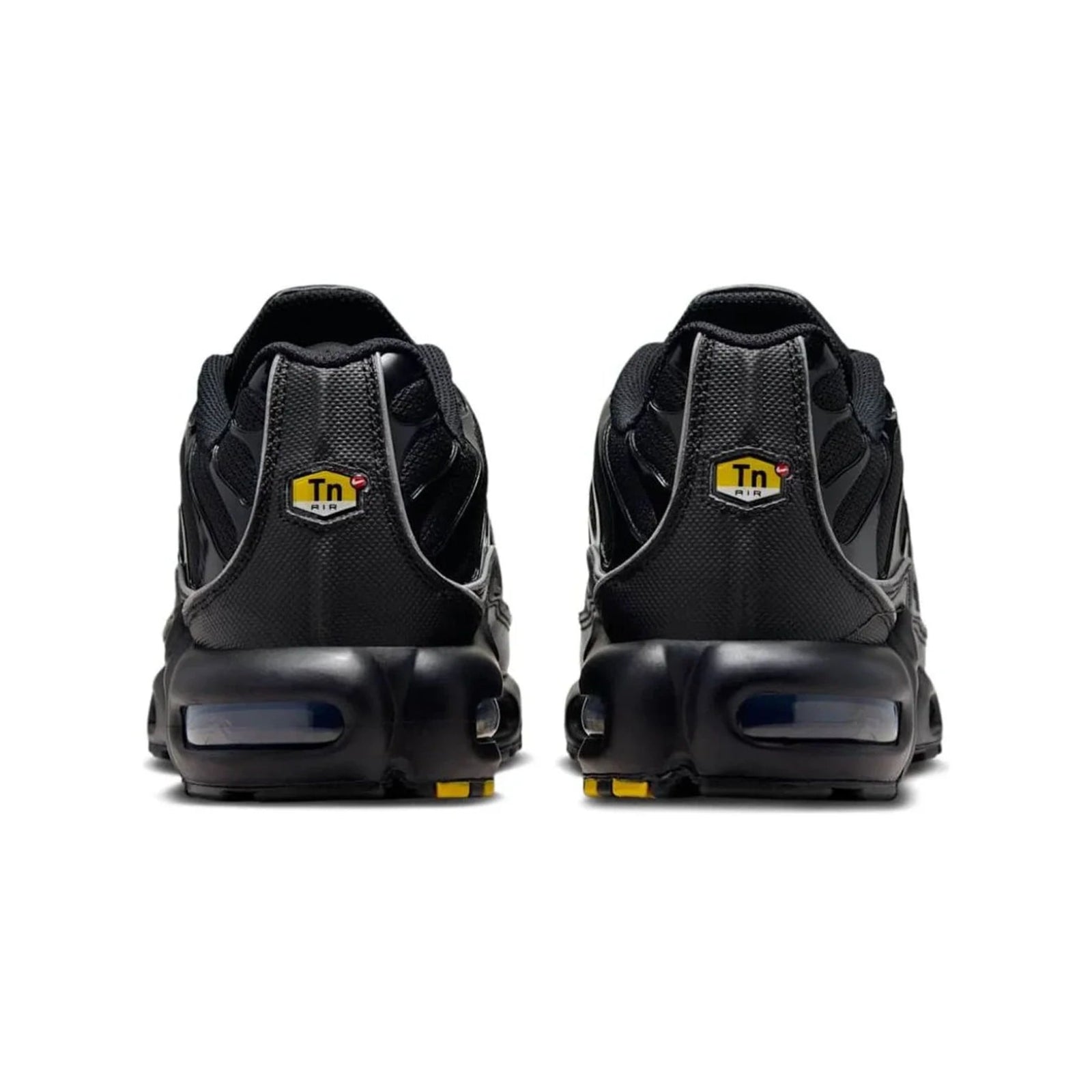 Black sneakers with yellow accents on a white background