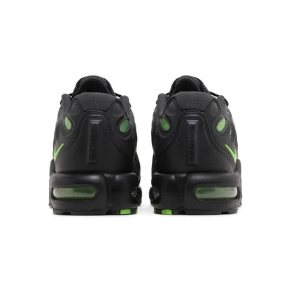 Black sneakers with green accents on a white background