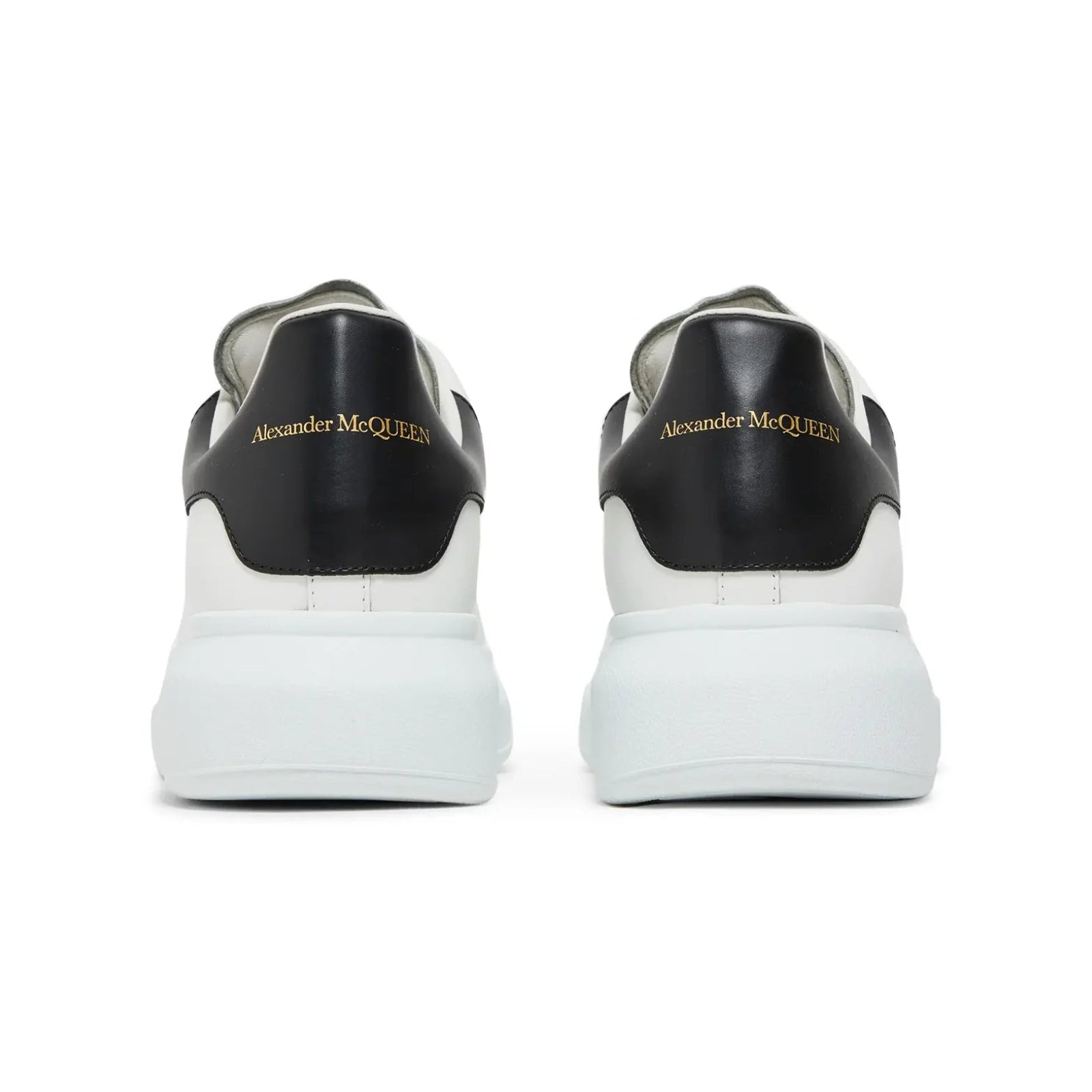 Black and white sneakers with 'Alexander McQueen' branding on a white background